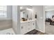 Bright bathroom featuring a double sink vanity with white cabinets and a bathtub at 5812 Flat Hill Dr, Indianapolis, IN 46239
