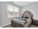 Bedroom with a tufted headboard and a sunlit window view at 5812 Flat Hill Dr, Indianapolis, IN 46239