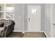 Bright entryway features a decorative front door, neutral walls, hardwood floors, and ample natural light from a nearby window at 5812 Flat Hill Dr, Indianapolis, IN 46239