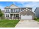 Attractive two-story home with gray siding, brick accents, manicured lawn, and a two-car garage, creating curb appeal at 5812 Flat Hill Dr, Indianapolis, IN 46239