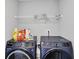 This laundry room is equipped with modern washer and dryer units and storage shelves for organizing laundry supplies at 5812 Flat Hill Dr, Indianapolis, IN 46239