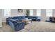 Bright living room with a large blue sectional, a patterned rug, and plenty of natural light at 5812 Flat Hill Dr, Indianapolis, IN 46239