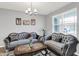 Bright living room with neutral walls, hardwood floors, elegant gray sofas, decorative pillows, and a stylish coffee table at 5812 Flat Hill Dr, Indianapolis, IN 46239