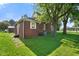 Backyard view of a brick home surrounded by lush green grass and mature shade trees at 590 W Washington St, Martinsville, IN 46151