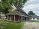 Classic brick home featuring a welcoming covered porch, ideal for relaxing and enjoying the outdoors at 590 W Washington St, Martinsville, IN 46151
