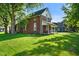 Side view of a charming brick home surrounded by lush green grass and mature shade trees at 590 W Washington St, Martinsville, IN 46151