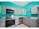 Stylish kitchen features grey cabinetry, stainless appliances and turquoise painted walls at 590 W Washington St, Martinsville, IN 46151
