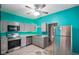 Turquoise kitchen with stainless steel appliances, grey cabinets, and tile floor at 590 W Washington St, Martinsville, IN 46151