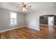 Neutral living room features wood floors, ceiling fan, white trim and an arched doorway at 590 W Washington St, Martinsville, IN 46151