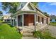 Charming brick home with a covered front porch featuring seating and flower boxes at 590 W Washington St, Martinsville, IN 46151