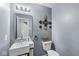 Modern half bathroom with a unique vessel sink, stylish mirror, and neutral color scheme at 6259 Teacup Dr, Indianapolis, IN 46235