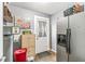 This mud room features a gray refrigerator, wooden cabinet, and a door with curtains at 6259 Teacup Dr, Indianapolis, IN 46235