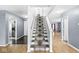 Carpeted staircase with hardwood floors, gray walls, and white trim leading to upper level at 6259 Teacup Dr, Indianapolis, IN 46235