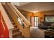 Inviting living room showcasing a carpeted staircase, neutral decor, and a comfortable gray sofa near the door at 6585 Dunsdin Dr, Plainfield, IN 46168