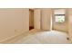 Bright bedroom featuring neutral carpet, window with blinds, and doorway leading to another room at 6965 Steinmeier W Dr, Indianapolis, IN 46220