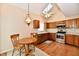 Charming kitchen with wood cabinets, stainless steel appliances, and table with seating, illuminated by natural light at 6965 Steinmeier W Dr, Indianapolis, IN 46220