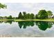 Pond view reflecting the sky with mature trees at 6965 Steinmeier W Dr, Indianapolis, IN 46220