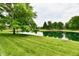 Scenic pond view with lush green landscaping surrounding the water's edge at 6965 Steinmeier W Dr, Indianapolis, IN 46220