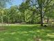 Expansive backyard with lush greenery, mature trees, and partial fencing at 7141 E Pleasant Run Pkwy S Dr, Indianapolis, IN 46219