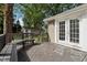 Wooden backyard deck with white french doors leading to the home and an outdoor bench at 7141 E Pleasant Run Pkwy S Dr, Indianapolis, IN 46219