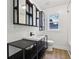 Modern bathroom with black vanity, bright white walls, and a window providing natural light at 7141 E Pleasant Run Pkwy S Dr, Indianapolis, IN 46219