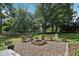 Backyard fire pit area with stone benches and seating surrounded by lush green trees at 7141 E Pleasant Run Pkwy S Dr, Indianapolis, IN 46219