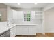 Bright kitchen featuring white cabinets, modern appliances, and a view of the outdoors at 7141 E Pleasant Run Pkwy S Dr, Indianapolis, IN 46219