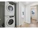 Stackable washer and dryer, next to a doorway with a view to the toilet at 7141 E Pleasant Run Pkwy S Dr, Indianapolis, IN 46219