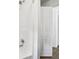 Bright white tiled shower and showerhead, with a view to the hall outside at 7141 E Pleasant Run Pkwy S Dr, Indianapolis, IN 46219