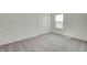 A bedroom features gray carpet, a window letting in light, and neutral paint at 7501 Firecrest Ln, Camby, IN 46113