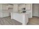 Bright kitchen with white cabinets, stainless steel appliances, island with sink, and stylish flooring at 7501 Firecrest Ln, Camby, IN 46113