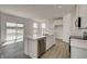 Modern kitchen with stainless steel dishwasher, island with sink, bright lighting, and a view of the lake at 7501 Firecrest Ln, Camby, IN 46113