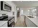 A close-up shot of a kitchen, featuring an oven, stove, and a staircase in the background at 7501 Firecrest Ln, Camby, IN 46113