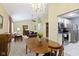Open-concept living with dining area, decorative chandelier, wood table and chairs, and views of the kitchen and living room at 786 Woodview North Dr, Carmel, IN 46032