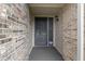 Close-up of the home's secure front entrance with a detailed security door, brick surround, and welcoming light fixture at 786 Woodview North Dr, Carmel, IN 46032