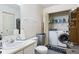Bathroom featuring a sink, toilet, and in-closet washer and dryer unit at 8038 Midlothian Way, Indianapolis, IN 46214