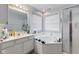 Bright bathroom features a bathtub with windows and a shower with glass doors at 8038 Midlothian Way, Indianapolis, IN 46214
