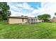 An expansive backyard featuring a well-maintained lawn, sunroom, and brick exterior, ideal for outdoor living and entertaining at 823 Rustic Rd, Anderson, IN 46013