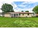 Well-maintained yard with lush green grass, perfect for entertaining, with a sunroom attached to the brick ranch home at 823 Rustic Rd, Anderson, IN 46013