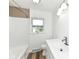 Bright bathroom with white shiplap walls, modern vanity, and wood-look flooring, creating a fresh and clean space at 823 Rustic Rd, Anderson, IN 46013