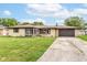 Charming single-story home featuring a brick facade, attached garage, and well-manicured front lawn on a sunny day at 823 Rustic Rd, Anderson, IN 46013