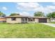 Inviting single-story home with brick exterior, enclosed porch, and attached garage, set against a lush green lawn at 823 Rustic Rd, Anderson, IN 46013