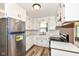 Well-lit kitchen features white cabinets, stainless steel appliances, and faux marble counters at 823 Rustic Rd, Anderson, IN 46013