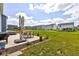 Spacious backyard with a concrete patio featuring an umbrella-covered table, grill, and hot tub at 853 Woodbridge Way, Lebanon, IN 46052