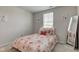 Bright bedroom featuring a floral comforter, plush pillows, natural light, and a stylish full-length mirror at 853 Woodbridge Way, Lebanon, IN 46052