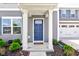 Welcoming front entryway boasting a blue door, white pillars, and well-kept landscaping, creating a charming first impression at 853 Woodbridge Way, Lebanon, IN 46052