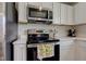 Close-up of modern kitchen appliances, white cabinetry, and quartz countertops at 853 Woodbridge Way, Lebanon, IN 46052