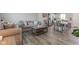 Open-concept living room showcasing contemporary furnishings and sleek floors, seamlessly connected to the dining area and kitchen at 853 Woodbridge Way, Lebanon, IN 46052