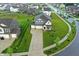 Aerial view of a charming new construction home with a covered porch, lush lawn, concrete driveway and landscaping at 8547 Winton Pl, Pendleton, IN 46064