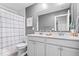 Bathroom with double sinks, a shower with a curtain, a toilet, and gray walls at 8547 Winton Pl, Pendleton, IN 46064